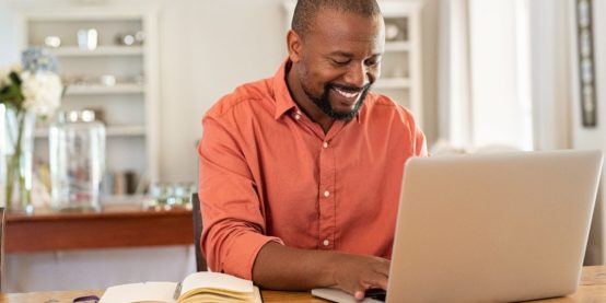 bigstock Smiling black man using laptop 306851869 1