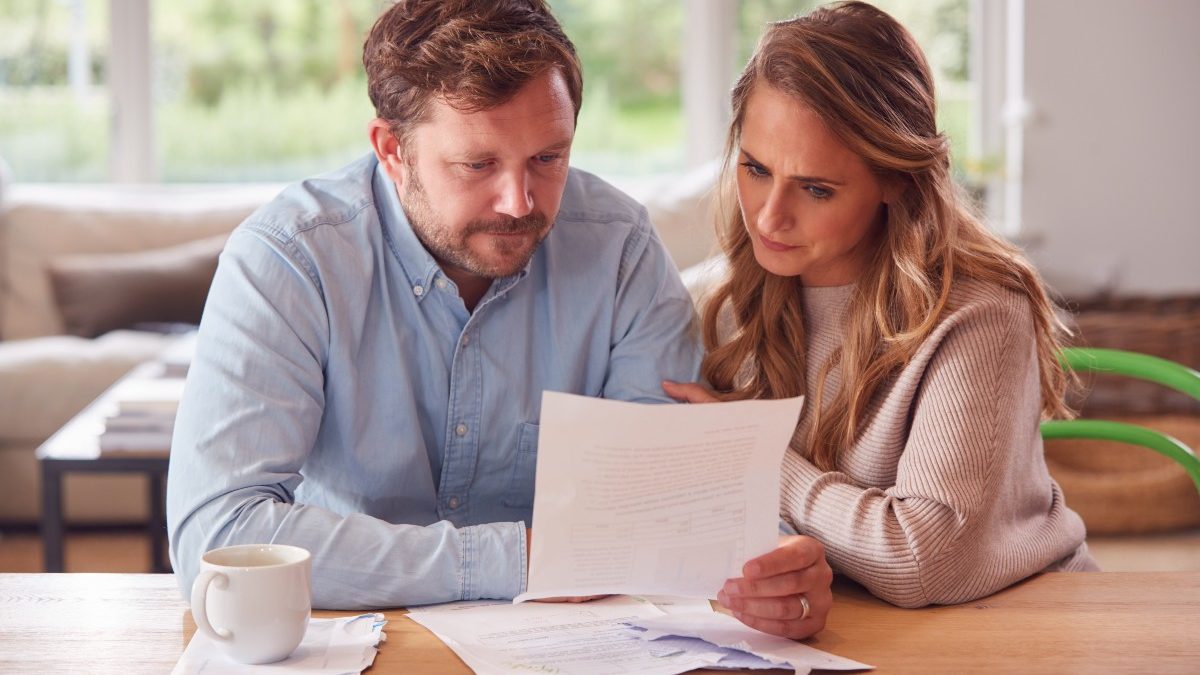 bigstock Worried Couple With Bills And 407283308 1